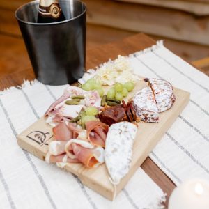Planche de charcuterie et champagne dans un hébergement insolite en Midi-Pyrénées.