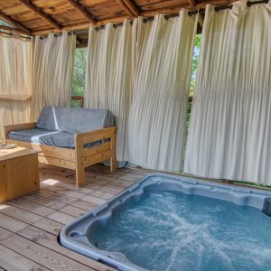 Cabane perchée avec jacuzzi, offrant une vue sur la nature environnante.