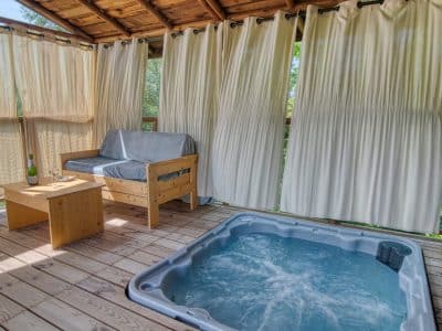 Cabane perchée avec jacuzzi, offrant une vue sur la nature environnante.