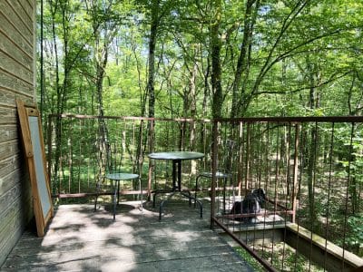 Cabane perchée en Bourgogne avec terrasse en bois entourée de verdure.