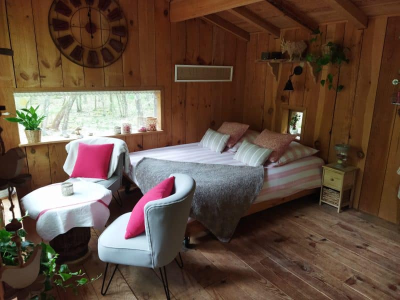 Chalet en bois chaleureux avec lit double et décoration naturelle.