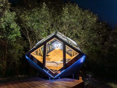 Cabane en bois suspendue, éclairage doux et vue sur les étoiles dans la nature.