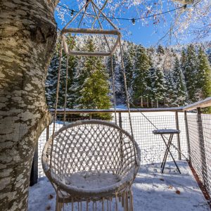 Hébergement insolite en Auvergne-Rhône-Alpes avec un hamac suspendu dans la neige.