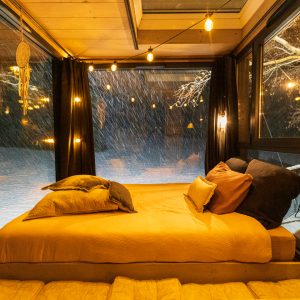 Cabane en verre à Auvergne-Rhône-Alpes, lit douillet avec vue sur la neige.