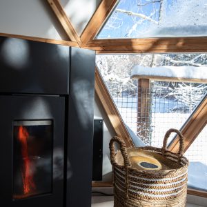 Hébergement insolite en Auvergne-Rhône-Alpes, avec poêle moderne et vue sur la neige.