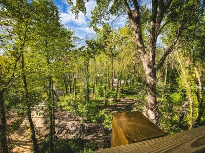 Cabane perchée en bois entourée dune forêt verdoyante en Île-de-France.