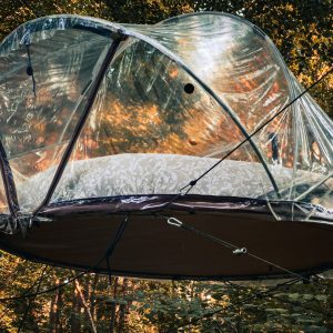 Cabane suspendue en pleine forêt, offrant une vue panoramique sur la nature.