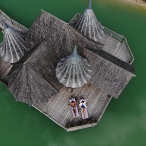 Hébergement insolite en Aquitaine : cabanes en bois sur pilotis au bord dun lac turquoise.