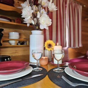 Hébergement insolite en Midi-Pyrénées : intérieur cosy avec vaisselle élégante et fleurs.