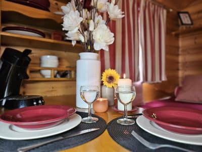 Hébergement insolite en Midi-Pyrénées : intérieur cosy avec vaisselle élégante et fleurs.