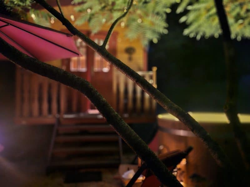 Cabane chaleureuse avec jacuzzi, éclairage doux et ambiance nocturne relaxante.