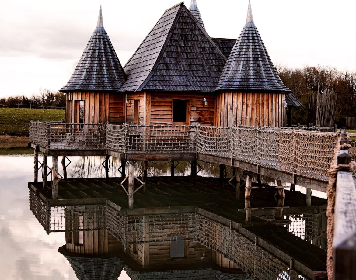 Cabane sur pilotis en Aquitaine, avec toits pointus et reflet dans leau.