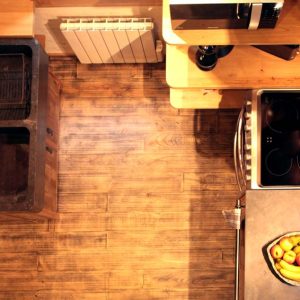 Hébergement insolite en Aquitaine : cuisine moderne avec un évier en pierre et un sol en bois.