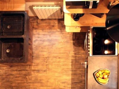 Hébergement insolite en Aquitaine : cuisine moderne avec un évier en pierre et un sol en bois.