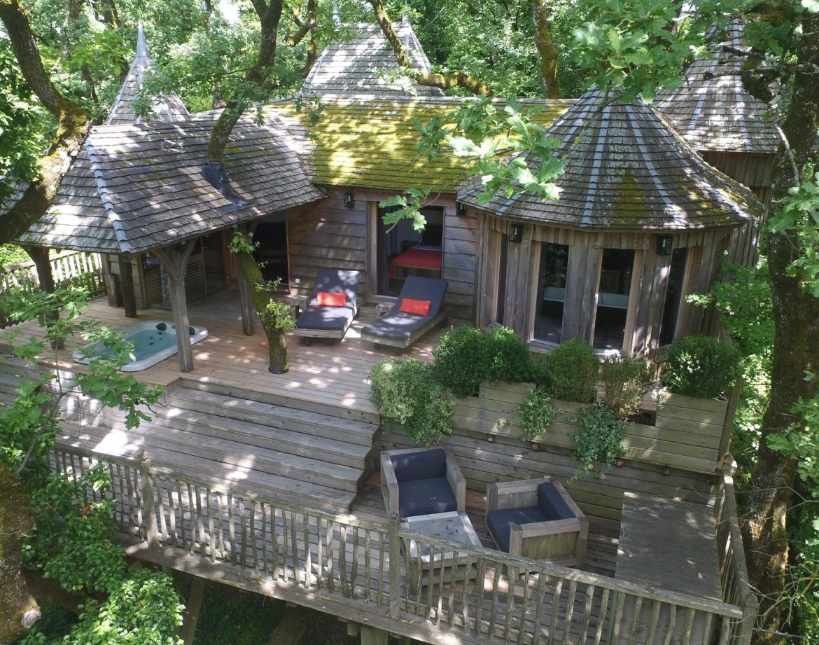 Cabane perchée en bois dans les arbres, avec terrasse et jacuzzi, en Aquitaine.