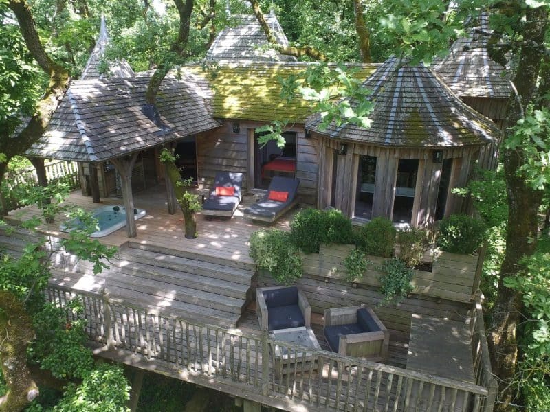 Cabane perchée en bois dans les arbres, avec terrasse et jacuzzi, en Aquitaine.