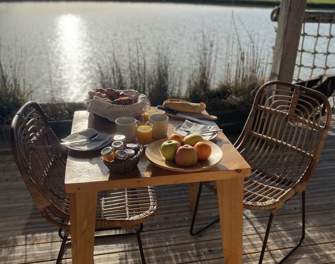 Hébergement insolite en Aquitaine : petit-déjeuner sur une terrasse au bord de leau.