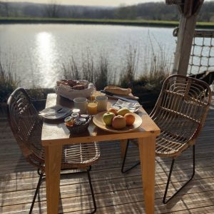 Hébergement insolite en Aquitaine : petit-déjeuner sur une terrasse au bord de leau.