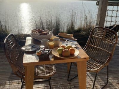 Hébergement insolite en Aquitaine : petit-déjeuner sur une terrasse au bord de leau.