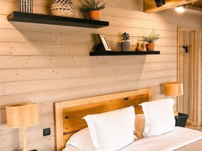 Chalet en bois chaleureux avec lit douillet et décoration végétale moderne.