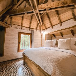 Cabane en bois avec un lit douillet et un plafond en bois chaleureux.