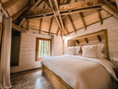 Cabane en bois avec un lit douillet et un plafond en bois chaleureux.