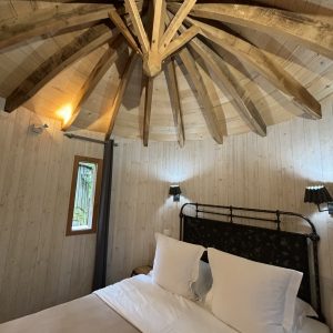 Chalet en bois avec un plafond en bois en étoile et un lit douillet.