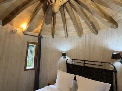 Chalet en bois avec un plafond en bois en étoile et un lit douillet.