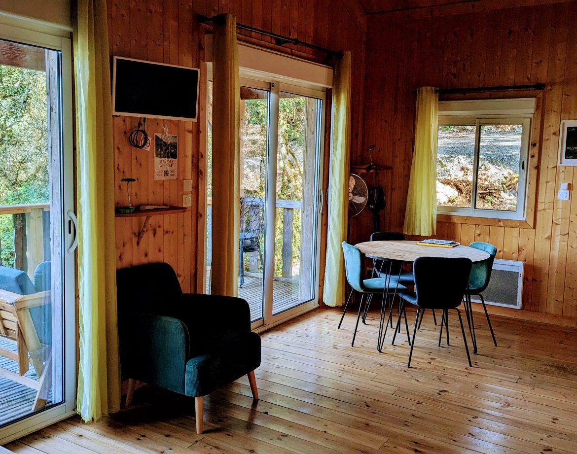 Cabane en bois lumineuse avec terrasse, vue sur la nature en Auvergne-Rhône-Alpes.