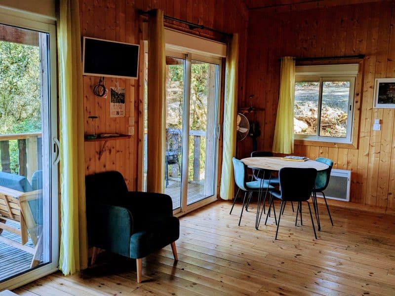 Cabane en bois lumineuse avec terrasse, vue sur la nature en Auvergne-Rhône-Alpes.