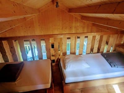 Cabane en bois avec lits douillets et vue sur la nature environnante.