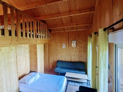 Cabane en bois avec mezzanine, intérieur chaleureux et lumineux en Auvergne-Rhône-Alpes.