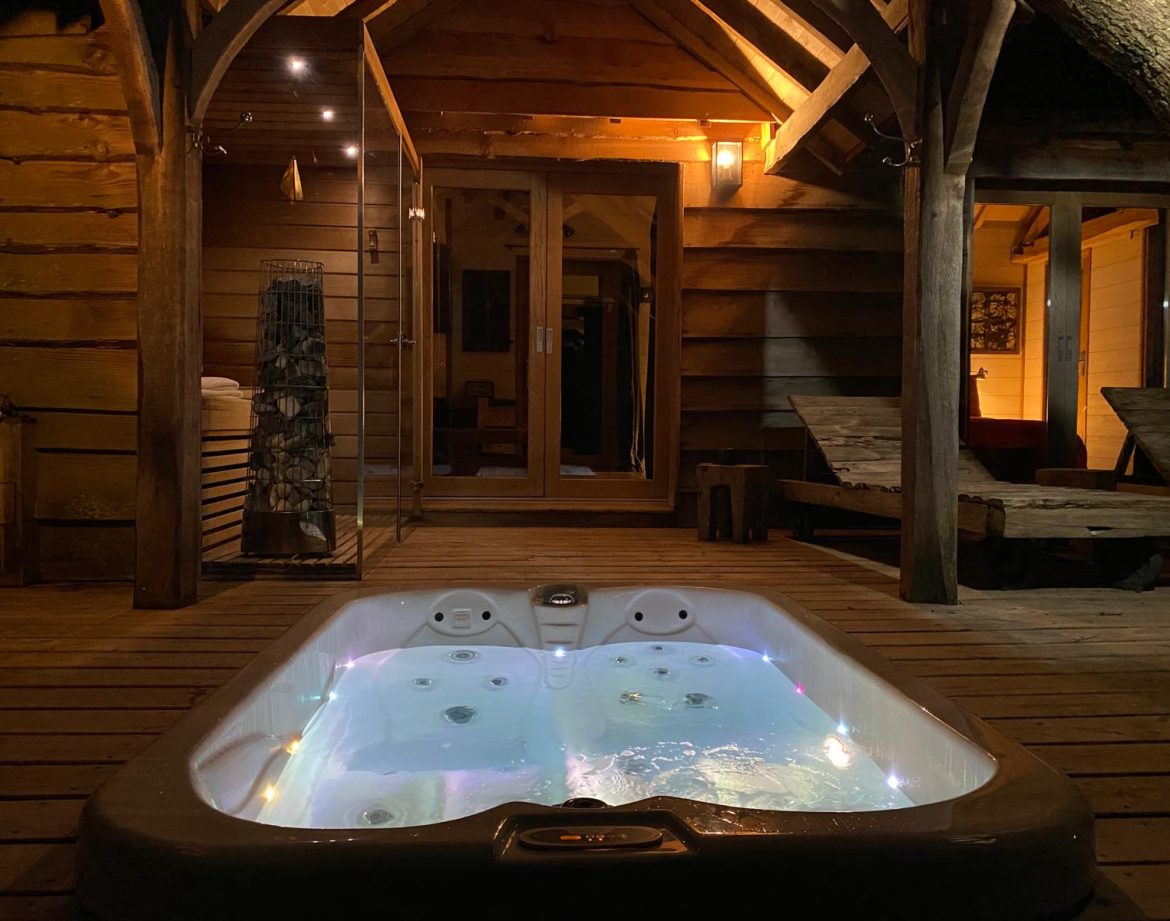 Hébergement insolite en Aquitaine : chalet en bois avec jacuzzi lumineux en extérieur.