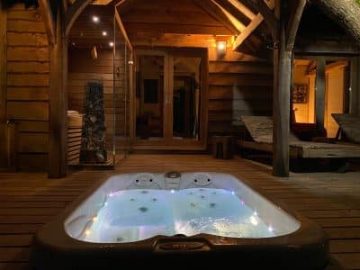 Hébergement insolite en Aquitaine : chalet en bois avec jacuzzi lumineux en extérieur.