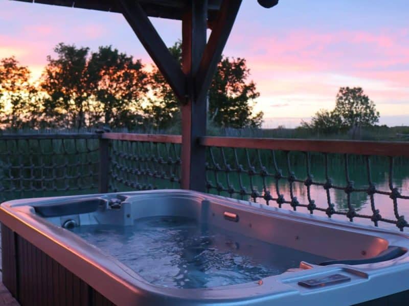 Cabane avec jacuzzi, offrant une vue imprenable sur le coucher de soleil.