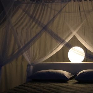 Chambre romantique en cabane, éclairée par une douce lumière sphérique.