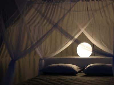 Chambre romantique en cabane, éclairée par une douce lumière sphérique.