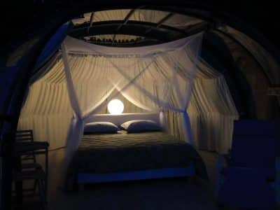 Hébergement insolite en Midi-Pyrénées : bulle transparente avec lit romantique et lumière douce.
