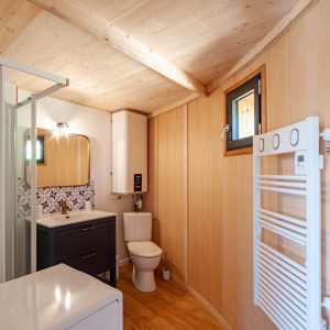Hébergement insolite en Aquitaine : salle de bain moderne avec bois clair et carrelage décoratif.