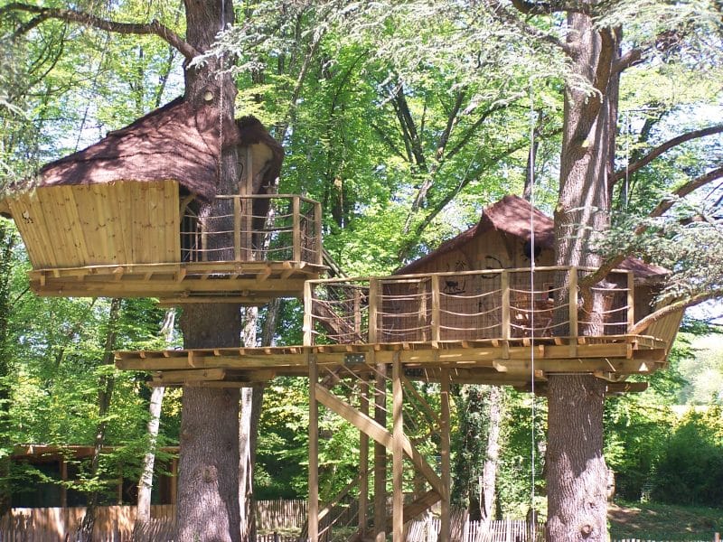 Cabane dans les arbres en Nouvelle-Aquitaine, perchée entre les feuillages verdoyants.
