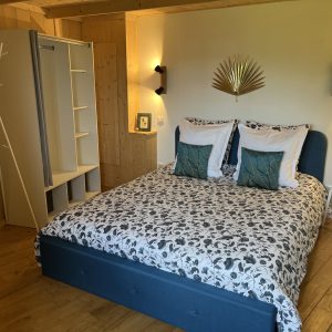 Chambre dhôtes moderne en bois, lit douillet avec linge à motifs élégants.