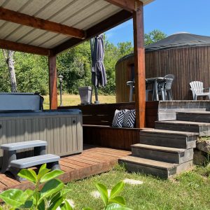 Yourte en Aquitaine avec jacuzzi, terrasse en bois et vue sur la nature.