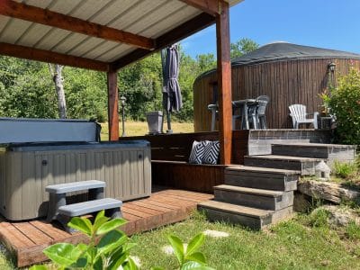 Yourte en Aquitaine avec jacuzzi, terrasse en bois et vue sur la nature.