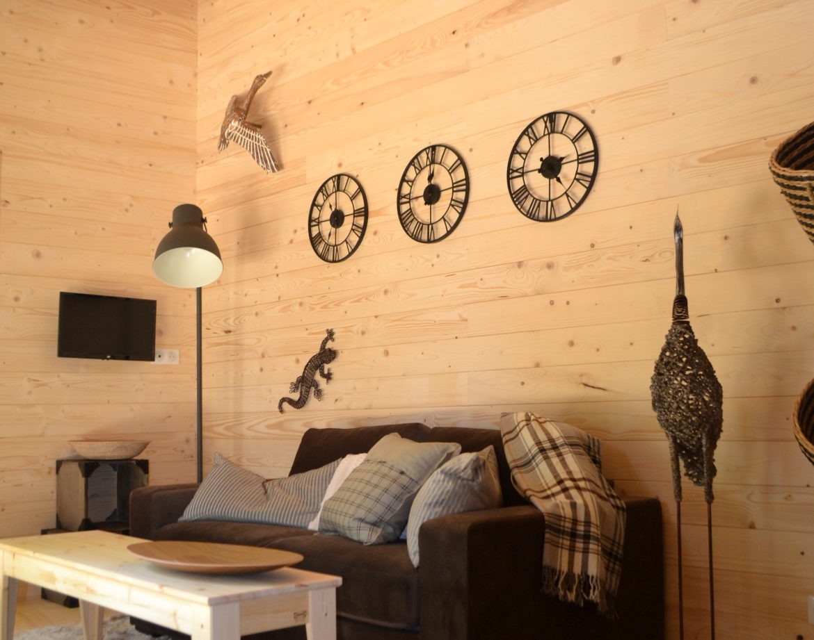 Cabane en bois moderne avec un intérieur chaleureux et des décorations murales.