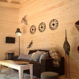 Cabane en bois moderne avec un intérieur chaleureux et des décorations murales.