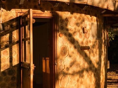 Hébergement insolite en Aquitaine : cabane en bois avec un toit en branches.