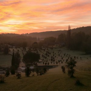 Hébergement insolite en Aquitaine, avec un coucher de soleil sur un paysage verdoyant.