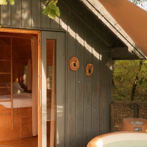 Cabane en bois avec jacuzzi, nichée dans la nature en Aquitaine.