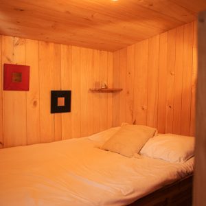 Cabane en bois chaleureuse avec lit douillet et éclairage tamisé.