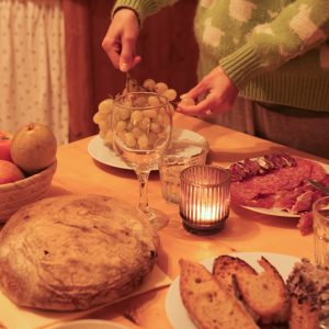 Hébergement insolite en Aquitaine : repas convivial avec pain, fruits et bougie.